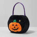 Black pumpkin Halloween candy bag with striped handle, three-quarter angle
