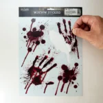 Hand applying a bloody handprint sticker to glass showing easy application