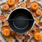 Black cauldron bucket with Halloween decorations flat lay