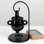 Black cauldron oil burner shown to scale next to a box of tealights