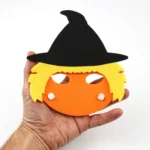 Hand holding a Halloween foam mask showing its child-friendly size