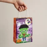 Hand holding the Halloween paper party bag to show its size
