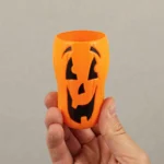 Hand holding a Halloween party cup showing its size