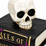 Close-up of the weathered skull sitting on top of the stacked Halloween books