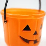 Close-up of the thin wire carry handle attachment on the orange Halloween bucket