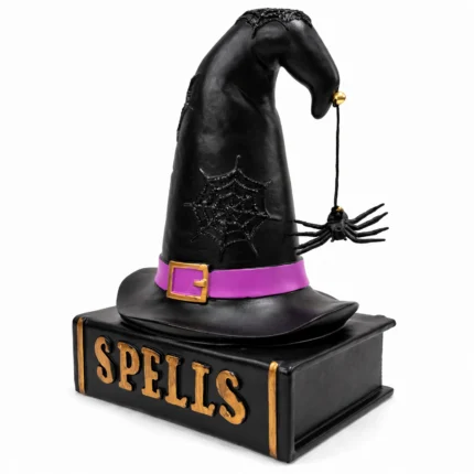 Witch hat spell book figurine from a three-quarter angle showing the dangling spider