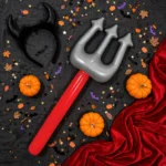 Flat lay of the inflatable devils fork with Halloween costume accessories