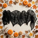Flat lay of the spider web mantel scarf with autumn props