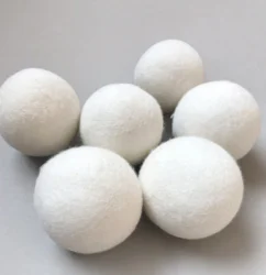 Six white wool dryer balls arranged in a group, front view